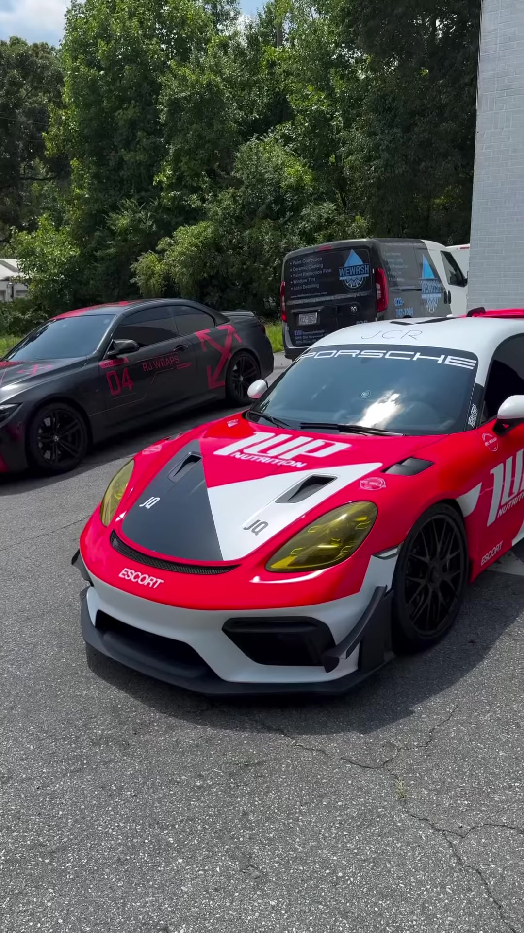 Porsche GT4 RS in red, white and black track livery outside our shop